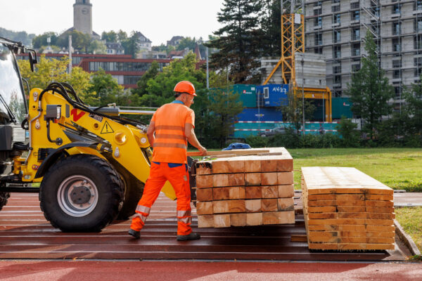 Sportplatz Waesserwies Entladung Holzelemente von Bagger